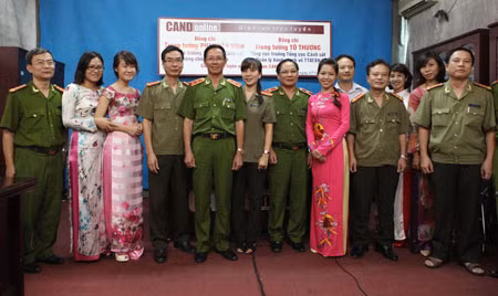 Thay mặt Ban Biên tập Báo CAND, Đại tá Nguyễn Hồng Thái - Phó Tổng Biên tập tặng quà cho Trung tướng thương binh Phan Văn Vĩnh nhân dịp 65 năm Ngày Thương binh liệt sỹ. Các vị khách mời chụp ảnh lưu niệm với cán bộ chiến sĩ Ban CAND Điện tử.