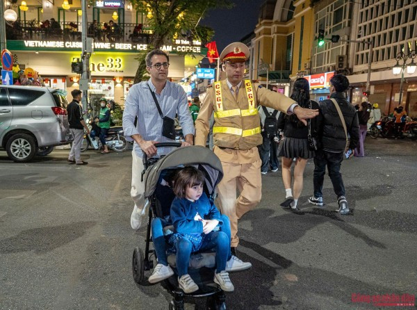 Cán bộ CSGT Hà Nội hỗ trợ du khách di chuyển tại khu vực trung tâm để đến điểm chờ đón xem bắn pháo hoa chào mừng năm mới 2026.