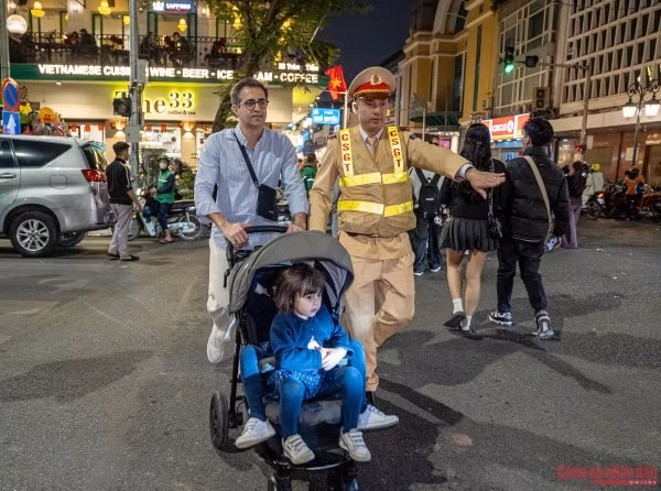 Cán bộ CSGT Hà Nội hỗ trợ du khách di chuyển tại khu vực trung tâm để đến điểm chờ đón xem bắn pháo hoa chào mừng năm mới 2026.