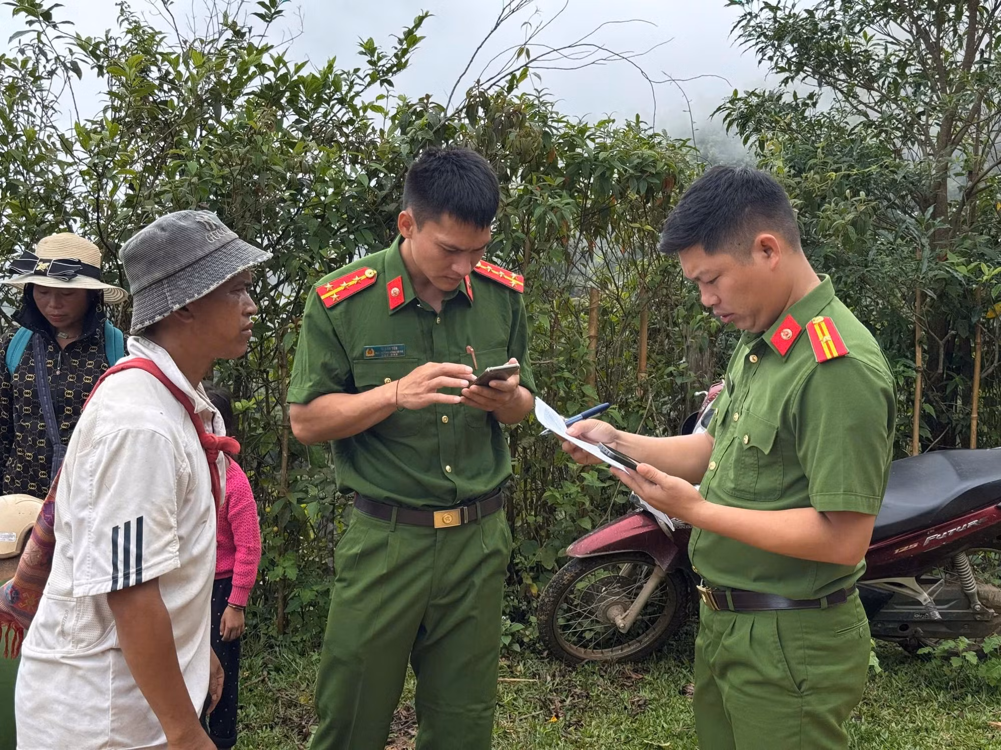 Cán bộ Công an xã Keng Đu “hóng sóng” trên đồi để kích hoạt tài khoản định danh điện tử mức độ 2, tích hợp giấy tờ và hướng dẫn người dân bản Khe Linh sử dụng VNeID
