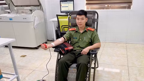 Đại úy Đặng Minh Tới đang hiến máu phục vụ ca cấp cứu hai mẹ con sản phụ.