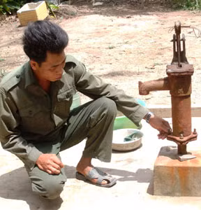 Ông Danh Văn Tài với giếng nước khoan xong, bỏ không.