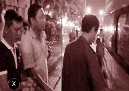 Phóng viên Kim Cương (dấu x) rời khỏi VPĐD Báo Thanh Niên khu vực Đông Nam Bộ dưới sự áp giải của lực lượng Công an.