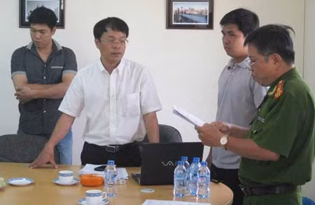 Vũ Văn Đảo (áo sơ mi trắng) nghe Cơ quan CSĐT đọc quyết định khởi tố bị can, lệnh bắt bị can để tạm giam và khám xét.