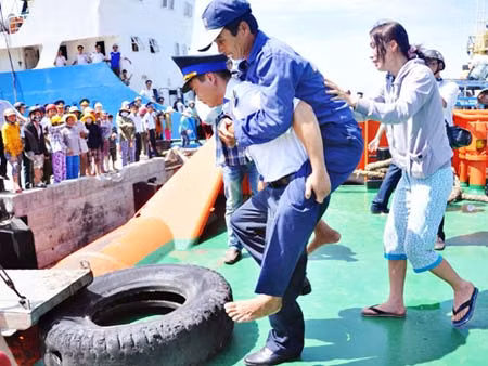 Chiến sĩ Vùng Cảnh sát biển 2 đưa ngư dân tàu cá QNa 91594 được cứu nạn lên bờ.