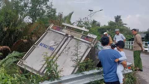 Xe tải tông lan can cầu rơi xuống kênh, tài xế mắc kẹt trong cabin