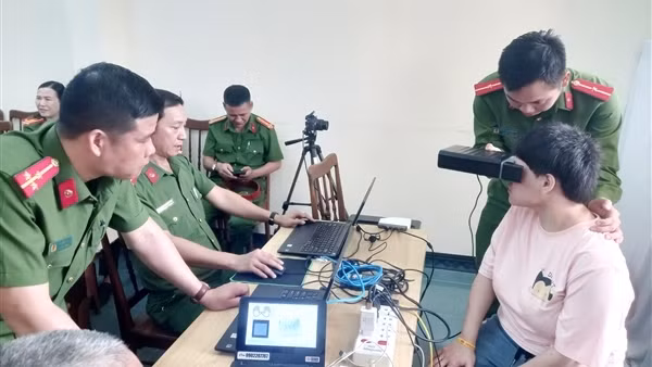 Cảnh sát vác gạo, dìu cụ già, bế trẻ em tại điểm cấp căn cước cho người khuyết tật