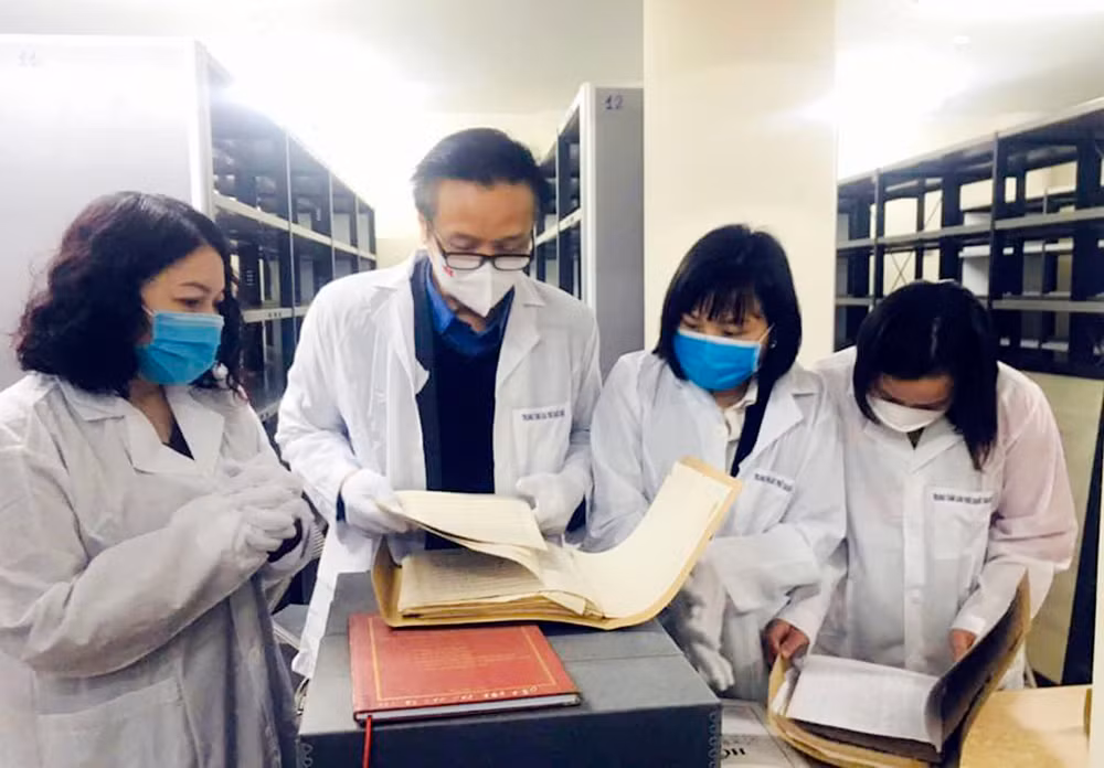 pgs.ts nhạc sĩ trọng lưu (giữa) xem bản thảo viết tay của nhạc sĩ trọng lưu tại trung tâm lưu trữ quốc gia iii.jpg -1