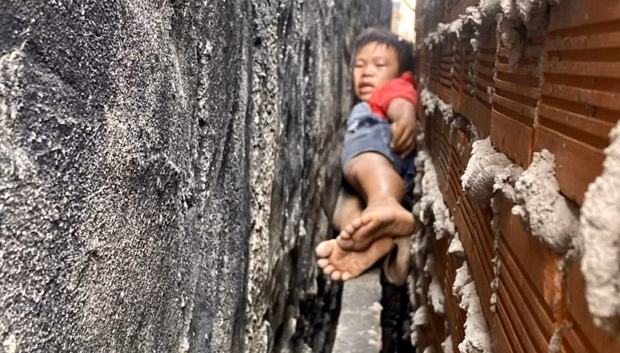20 phút nghẹt thở giải cứu bé trai mắc kẹt giữa vách 2 căn nhà -0