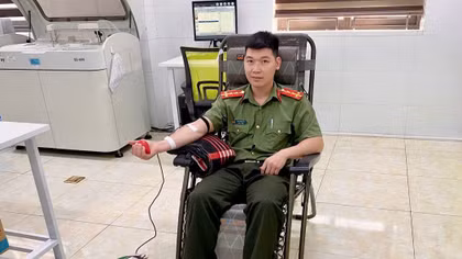 Đại úy Đặng Minh Tới đang hiến máu phục vụ ca cấp cứu hai mẹ con sản phụ.