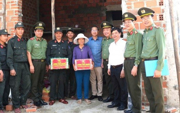 Tặng quà cho bà Huỳnh Thị Tho là người dân được hỗ trợ xây dựng nhà.