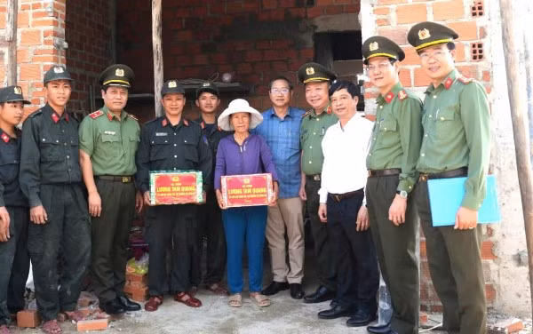 Tặng quà cho bà Huỳnh Thị Tho là người dân được hỗ trợ xây dựng nhà.