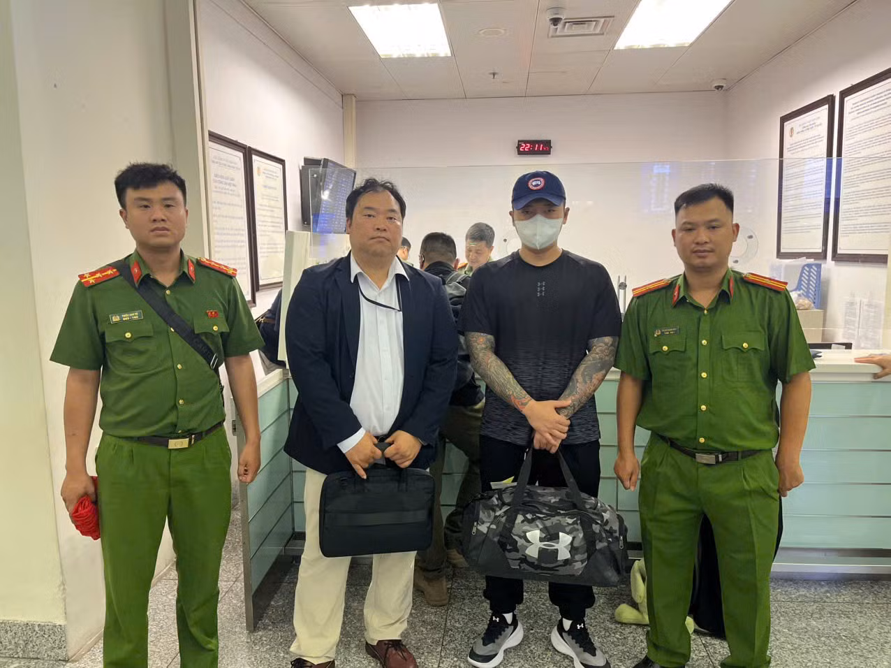 Lực lượng Công an bàn giao đối tượng Lee Sammin cho phía Hàn Quốc (áo đen, đứng thứ 3 từ trái sang).