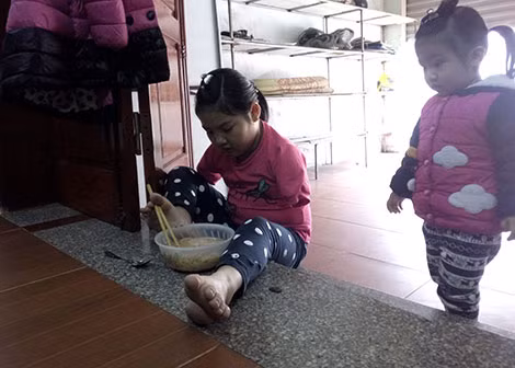 Cháu Sơn Dương dùng chân kẹp đũa để gắp đồ ăn. Cháu Sơn Dương dùng chân kẹp đũa để gắp đồ ăn.