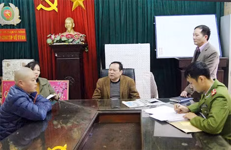 Đối tượng Lưu Trung Dũng (áo khoác xanh ngồi đầu bên trái ảnh) xin đầu thú và khai báo hành vi phạm tội tại Công an quận Hà Đông.