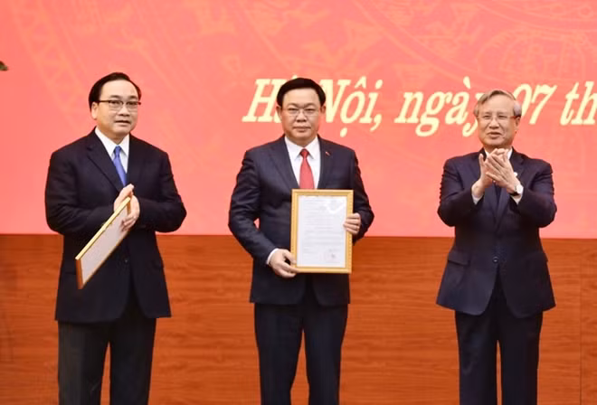 Thường trực Ban Bí thư Trần Quốc Vượng trao Quyết định của Bộ Chính trị phân công Phó Thủ tướng Vương Đình Huệ làm Bí thư Thành ủy Hà Nội.