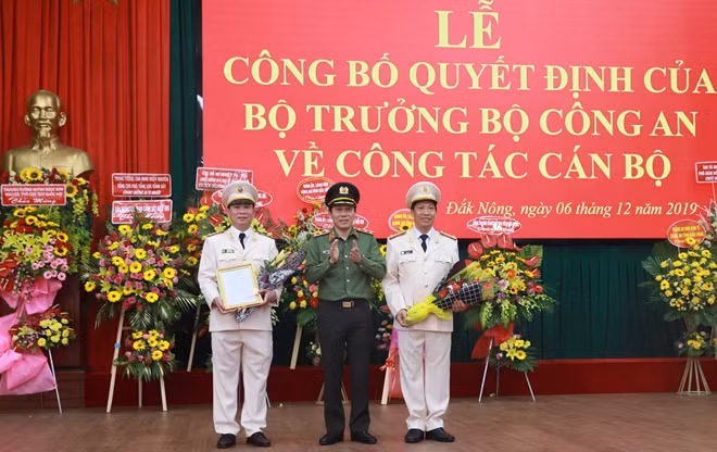 Thứ trưởng Lương Tam Quang trao quyết định, tặng hoa chúc mừng cho các đồng chí Đại tá Hồ Văn Mười và Lê Văn Tuyến tại buổi lễ.