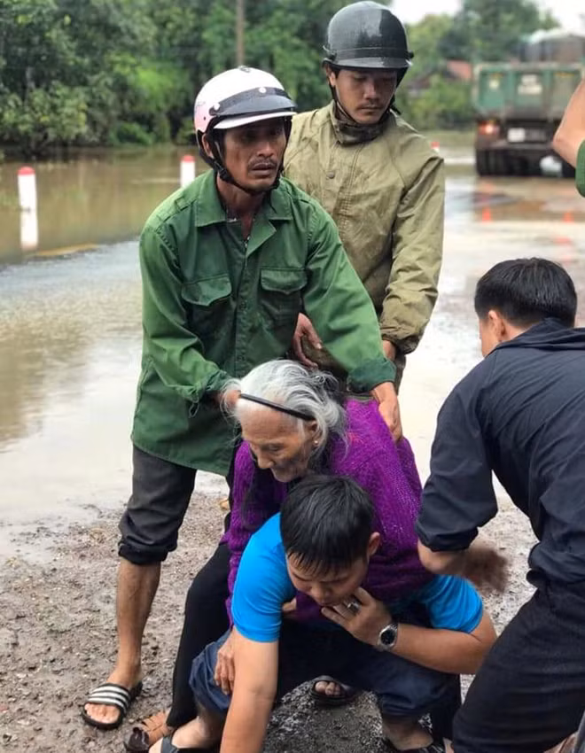 Lực lượng Dân quân và Công an cõng một người già đến nơi an toàn