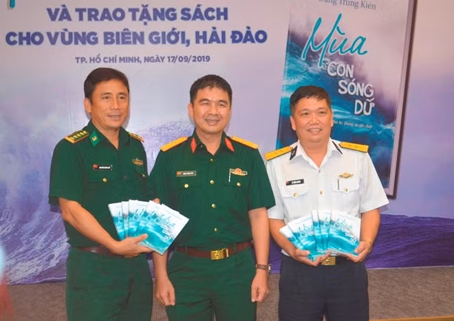 Thiếu tá, nhà báo Đặng Trung Kiên tặng sách cho đại diện cán bộ chiến sĩ biên phòng, hải quân.