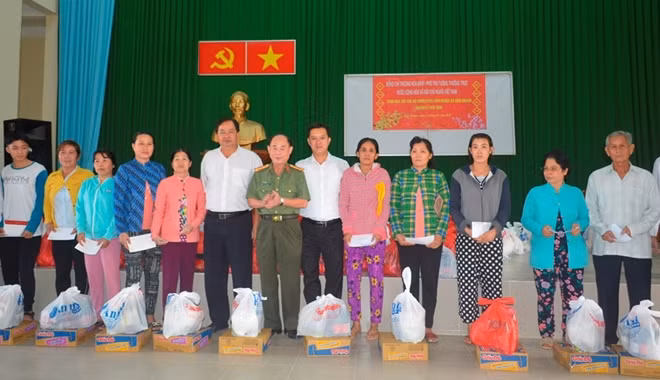 Đại tá Trần Kim Thẩm, Phó Tổng biên tập Báo CAND và các nhà hảo tâm tặng quà cho gia đình chính sách và người nghèo xã Bình Khánh, huyện Cần Giờ.