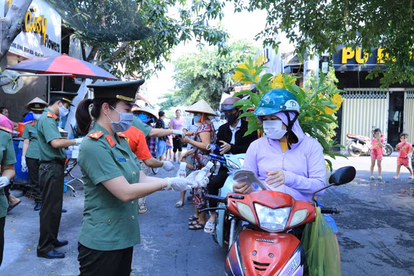 Đoàn viên, hội viên Phòng Tổ chức cán bộ phát nước rửa tay diệt khuẩn và khẩu trang cho công nhân và người dân KP5A, phường Long Bình, TP Biên Hòa.
