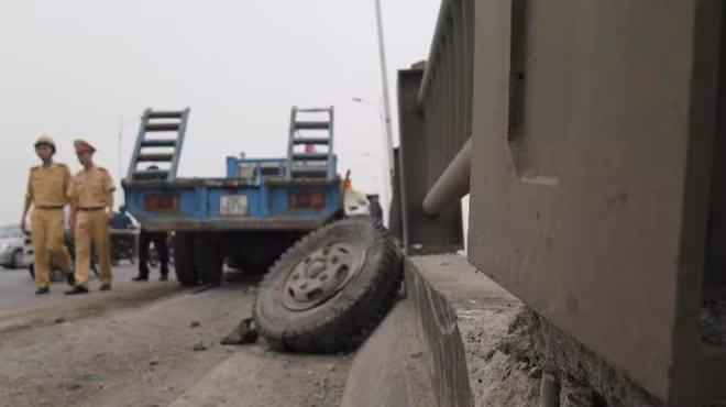Bánh xe trước xe tải văng ra ngoài, thành cầu bị vỡ nứt.