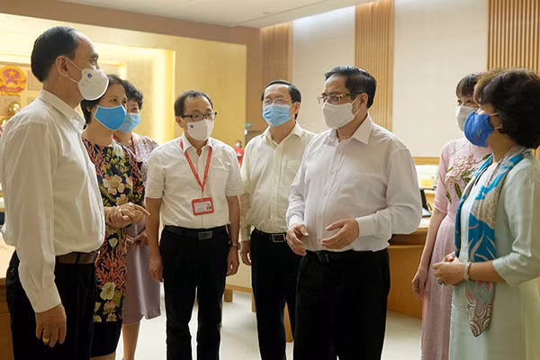Thủ tướng Phạm Minh Chính trao đổi với các đại biểu tham dự cuộc làm việc.