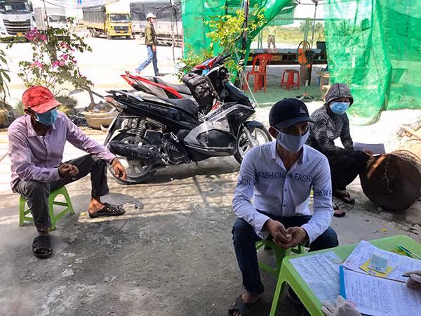 Tài xế (mặc áo trắng, đội mũ đen) và người trốn vào thùng xe (đội mũ đỏ).