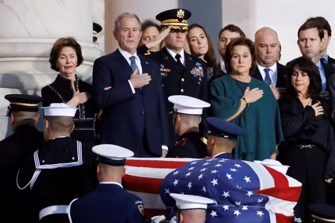 Cựu Tổng thống George W. Bush, con trai của cố Tổng thống George H. W. Bush, cùng các thành viên trong gia đình đặt tay lên ngực khi linh cữu của cố Tổng thống Bush "cha" được đưa vào bên trong tòa nhà Quốc hội.