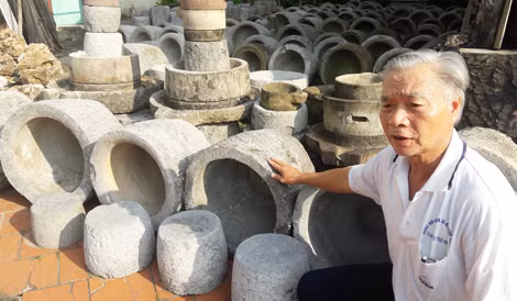 Ông Nguyễn Đắc Nông bên những chiếc cối đá.