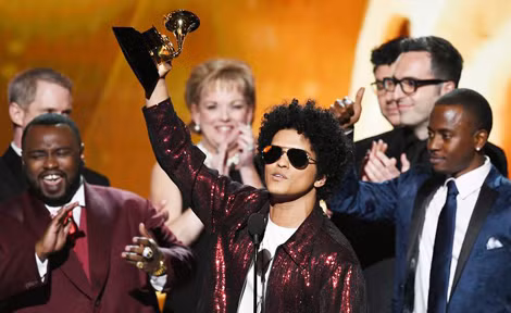 Bruno Mars giơ cao chiếc cúp chiến thắng tại giải Grammy.
