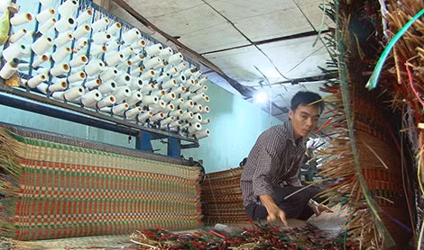 Anh Tân bên cơ sở sản xuất chiếu của gia đình.