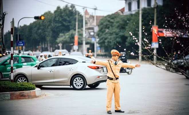 Chiến sĩ CSGT đang điều hành giao thông tại một ngã tư ở TP Vinh trong dịp Tết Bính Thân (Tác giả: Văn Hoàng Trung).