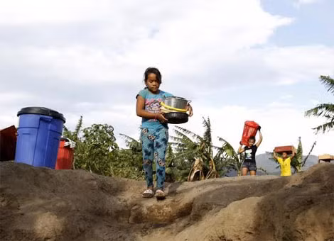 Một bé gái người Colombia đang đi bộ đến bờ sông Tachira.