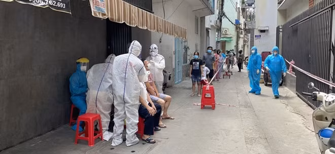 Ngành y tế địa phương lấy mẫu xét nghiệm tầm soát cho người dân tại khu vực phong toả thuộc phường 9, quận Tân Bình.