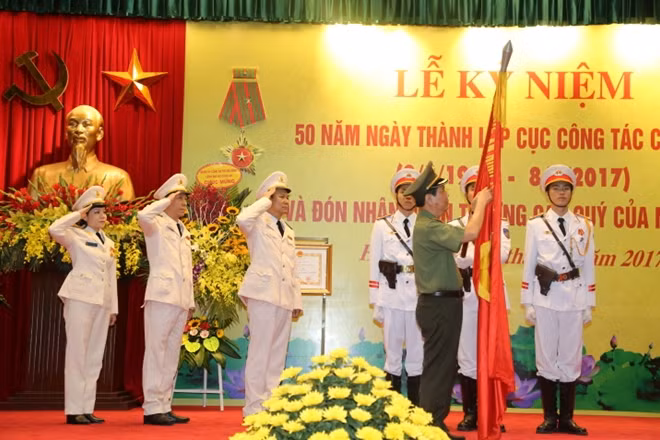 Thứ trưởng Nguyễn Văn Sơn gắn Huân chương Lao động hạng Ba lên Cờ truyền thống của Đoàn Kịch nói Công an nhân dân