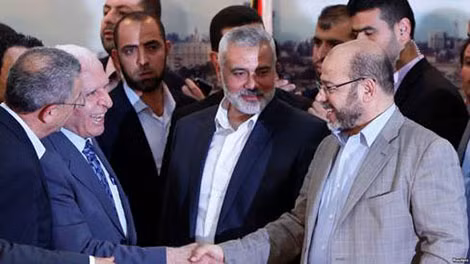 Giới chức cấp cao của nhóm Fatah Azzam Al-Ahmed (trái) bắt tay với thủ lĩnh nhóm Hamas Moussa Abu Marzouq sau khi công bố thỏa thuận tại Cairo.