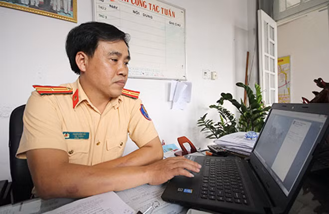 Thiếu tá Phạm Hồng Hải tranh thủ thời gian làm việc để quản trị trang Facebook của CSGT Đà Nẵng. Ảnh: Nguyễn Đông.