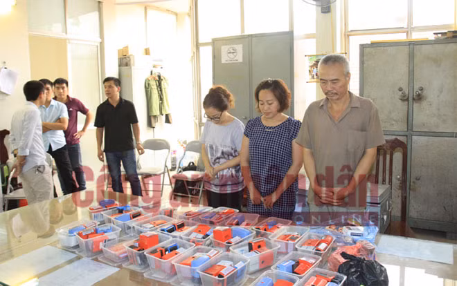 Đối tượng Hoàng Lệ Hằng (áo xanh đứng giữa) và Vũ Kim Oanh, Nguyễn Anh Tuấn, cùng tang vật tại Cơ quan ANĐT.