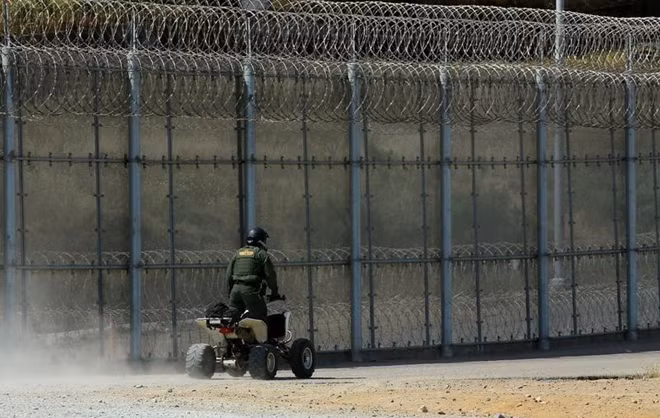 Lính Mỹ đi tuần tại một khu vực tường rào giữa biên giới Mỹ - Mexico. Ảnh: Reuters