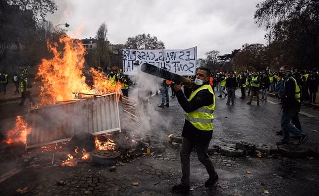 Người biểu tình đốt đồ đạc ở Paris. Ảnh: EPA