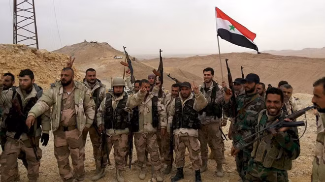 Quân đội Syria ăn mừng chiến thắng trong một trận chiến ở khu vực Palmyra. Ảnh: Al Jazeera