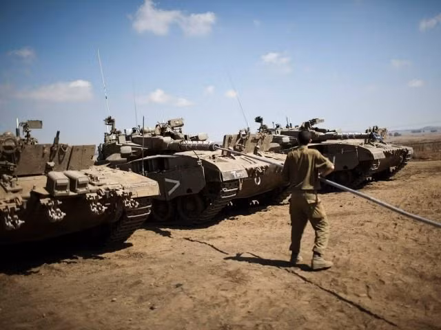 Binh sĩ quân đội Israel lau chùi nòng pháo gần biên giới Lebanon. Ảnh: ToI