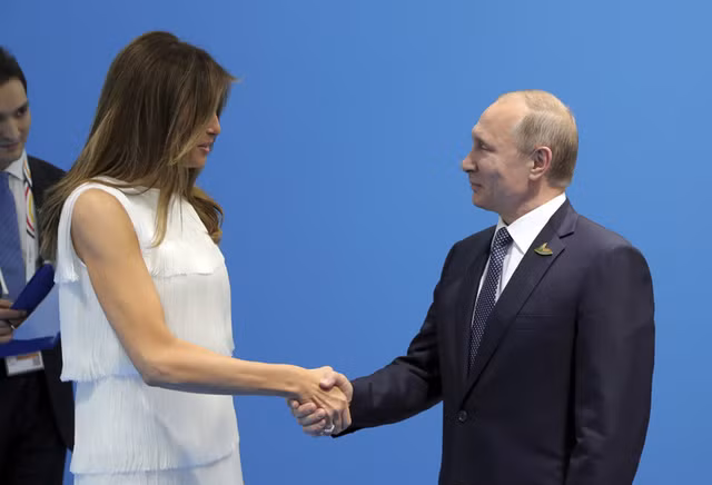 Tổng thống Putin bắt tay Đệ nhất phu nhân Melania Trump. Ảnh: Reuters