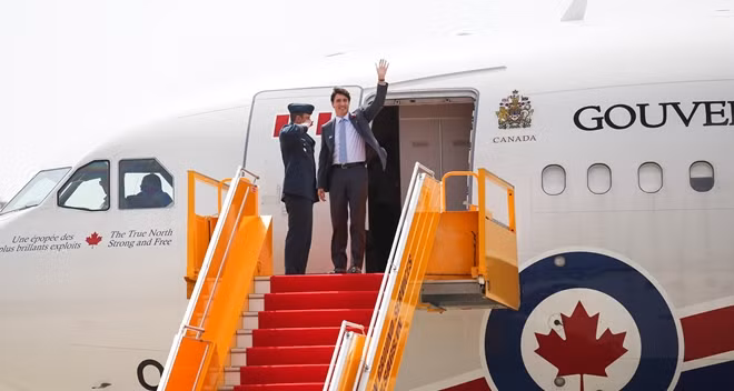 Thủ tướng Canada vẫy tay chào khi bước ra chuyên cơ.
