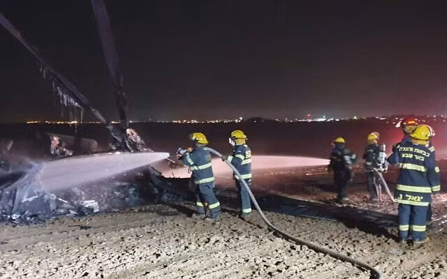 Lính cứu hỏa phun nước vào chiếc trực thăng. Ảnh: WA