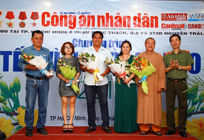 Thiếu tướng Phạm Văn Miên, Tổng biên tập Báo CAND tặng hoa cho các doanh nghiệp, nhà hảo tâm đồng hành cùng Chương trình Tết vì người nghèo.