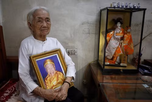 Bà Nguyen Thi Xuan ôm ảnh chân dung người chồng Nguyen Van Duc, một binh lính Nhật Bản, tại ngôi nhà ở Hà Nội. Ảnh: Reuters