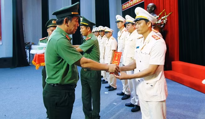 Đại tá Nguyễn Viết Lợi trao quyết định điều động về cơ sở cho các đồng chí Công an chính quy.
