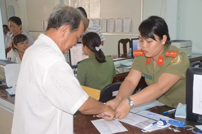 Cán bộ, chiến sĩ Phòng QLXNC Công an tỉnh Sóc Trăng, làm giấy tờ xuất, nhập cảnh cho người dân.